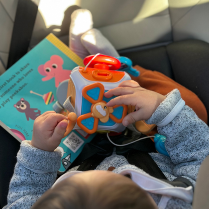 Child playing with a toy in a car seat